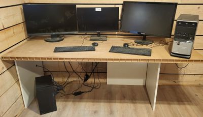 un bureau sur lequel sont posés deux écrans d'ordinateur et un clavier