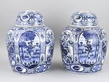 two blue and white vases with pictures of people on them