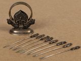 five forks and a spoon with a ring on top of them