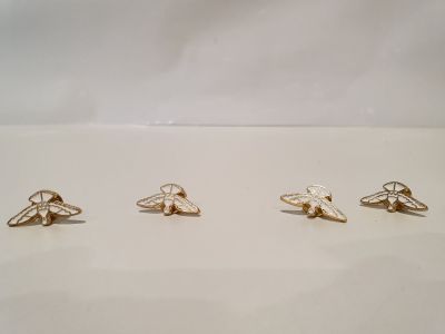 quatre paires de boucles d'oreilles en forme d'abeille dorées sur un fond blanc