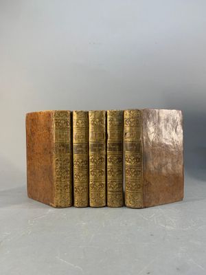 six vieux livres sont empilés sur une table