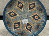 une image représentant une assiette bleue et orange ornée d'un motif floral