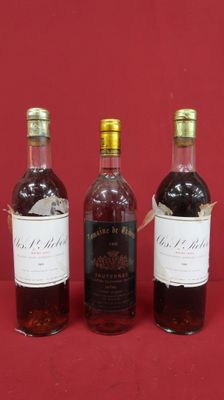 three bottles of wine are lined up on a red surface