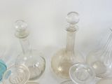cinq bouteilles en verre et une bouteille en verre vide sur la table