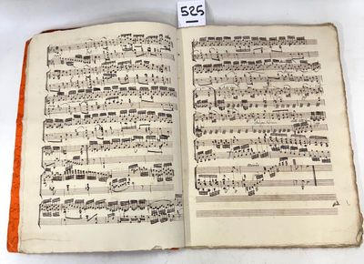 an open book with music notes on it sitting on a table