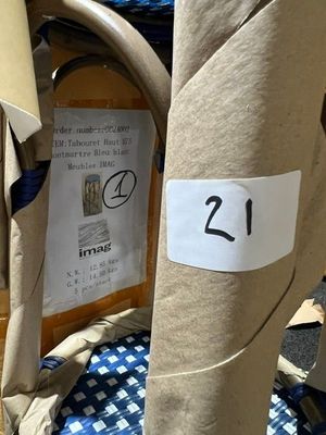 une table sur laquelle sont posés plusieurs sacs et une pancarte indiquant « 21 »