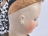 a small doll with a hat on top of it ' s head