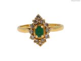 gros plan d'une bague en or avec une pierre verte