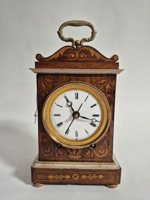 une petite horloge en bois avec des chiffres romains