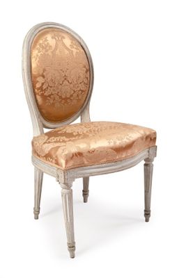 une image représentant une chaise dont l'assise est recouverte d'un tissu doré