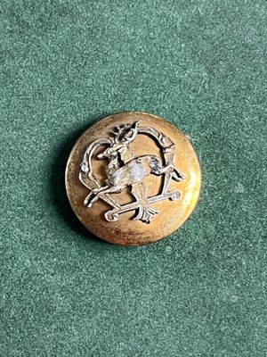 une image représentant un bouton en or orné d'un oiseau