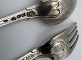 two spoons and a fork sitting on a table