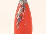 a red vase with a design on it on a white background