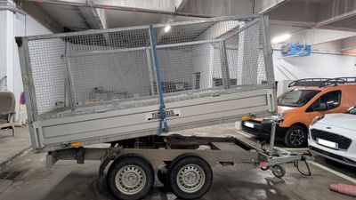 une remorque équipée d'une cage à l'arrière, dans un garage