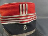 a red and black hat with a silver stripe on it