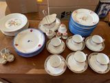 many plates and cups on a table with a box in the background