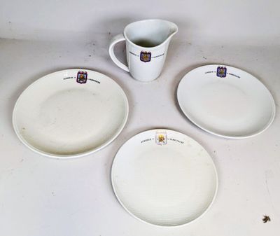 trois assiettes blanches et un pichet sont posés sur une table