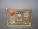 un assortiment de flacons de parfum dans une boîte transparente posée sur une table