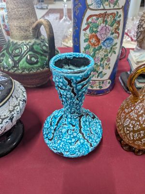 several vases are sitting on a table with a red table cloth