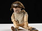 une poupée en bois posée sur une table, sur fond noir
