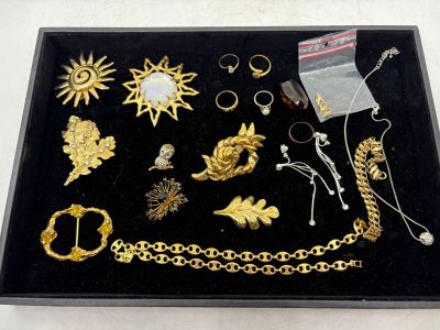 un plateau noir sur lequel sont posés des bijoux en or