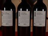 three bottles of wine sitting on top of a table next to a wooden box