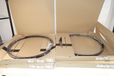 two empty boxes with a pair of rims in them