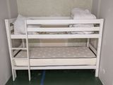 un lit superposé dans une petite chambre au sol vert