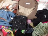 a pile of clothes that is sitting on a bed