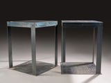 pair of metal side tables on a white surface with a black background