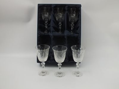 three empty wine glasses in a black box with a white background