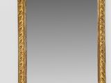 a gold framed mirror with a decorative design on the edge