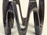 a metal sculpture of a wave on a white surface