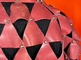 a woman wearing a pink and black jacket with a red and black design on it