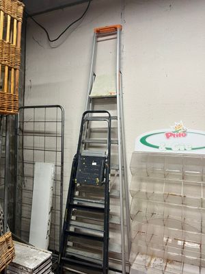 a ladder that is leaning against a wall next to a stack of boxes