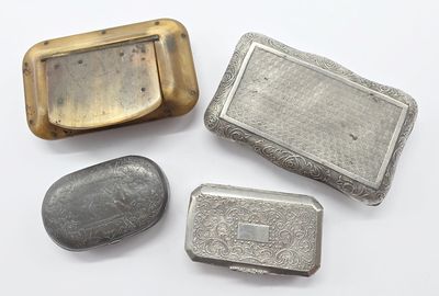 trois objets métalliques argentés posés sur une surface blanche, avec une pierre