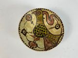 a decorative plate with a bird on it on a table