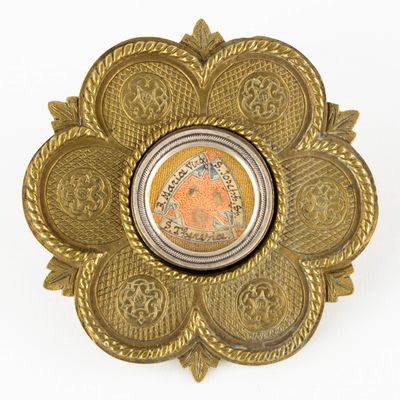 brass plate with a coin in the middle of it on a white surface
