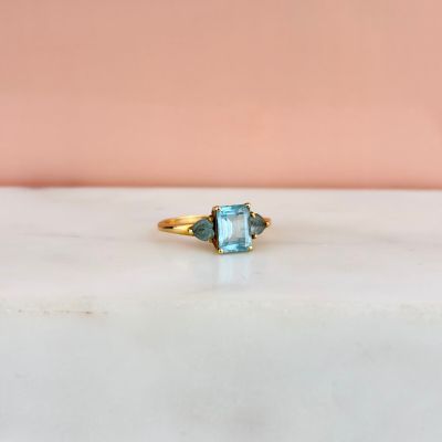 Gros plan sur une bague en or ornée d'une topaze bleue