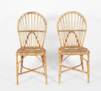 pair of wicker chairs with arms and backrests on a white background