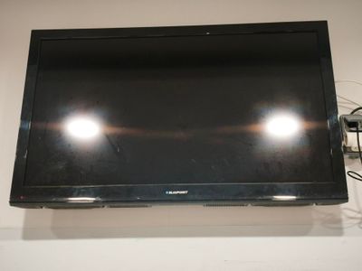 une télévision à écran plat fixée au mur au-dessus d'une table