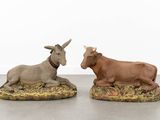 two figurines of a donkey and a donkey laying on top of each other