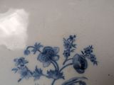 a blue and white plate with a flower design on it