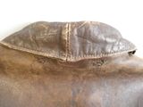 un gros plan d'une veste en cuir marron sur fond blanc