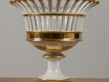 an image of a white and gold vase sitting on top of a wooden table