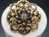 a close up of a gold and diamond ring on a white pedestal