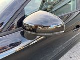 a reflection of a person taking a picture in the side view mirror of a car