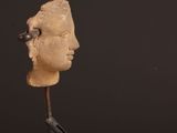 an image of a sculpture of a head on a wooden stand