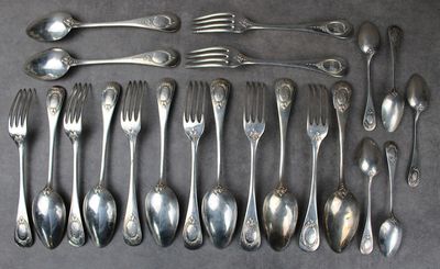 un grand nombre de cuillères et de fourchettes en argent disposées sur une table