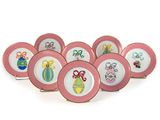 six assiettes roses et blanches, ornées de motifs variés, posées sur un fond blanc
